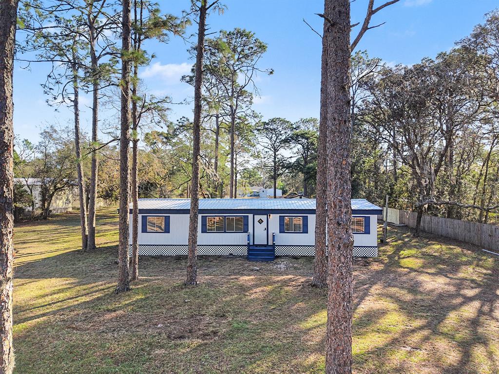 a view of a house with backyard and sitting area