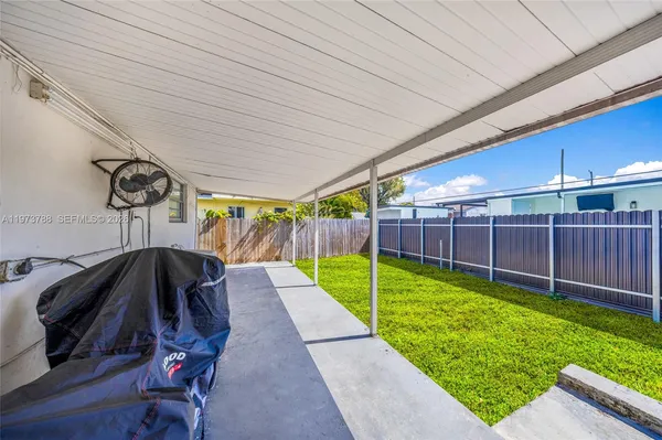 a view of a backyard with wooden fence