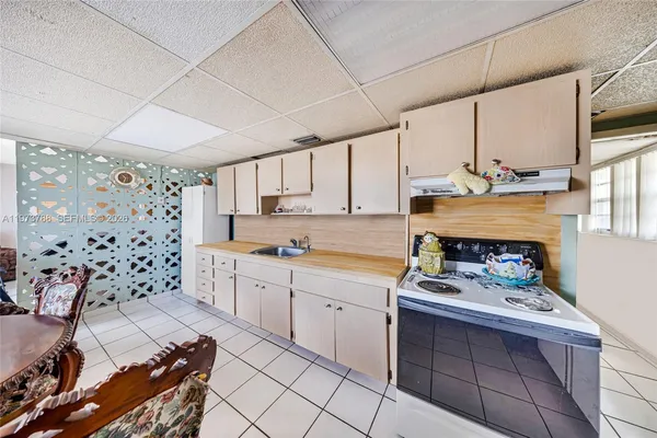 a kitchen with granite countertop a sink stove and cabinets