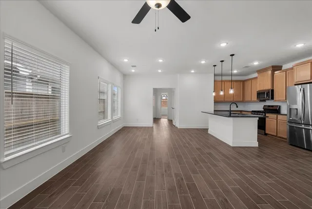 a view of kitchen with refrigerator stove and wooden floor