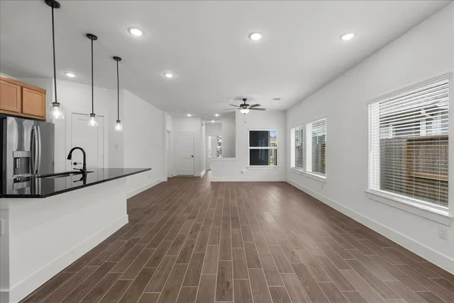 a view of a big room with wooden floor and windows