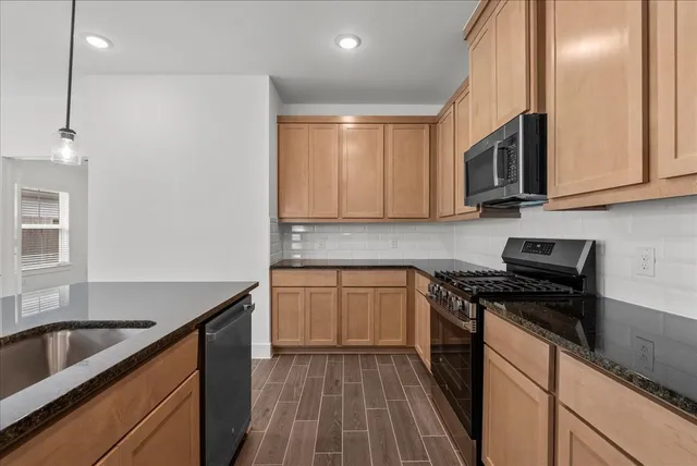 a kitchen that has a sink and a stove top oven