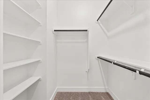 a view of walk in closet with empty racks