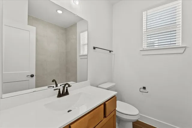 a bathroom with a sink a toilet and a mirror