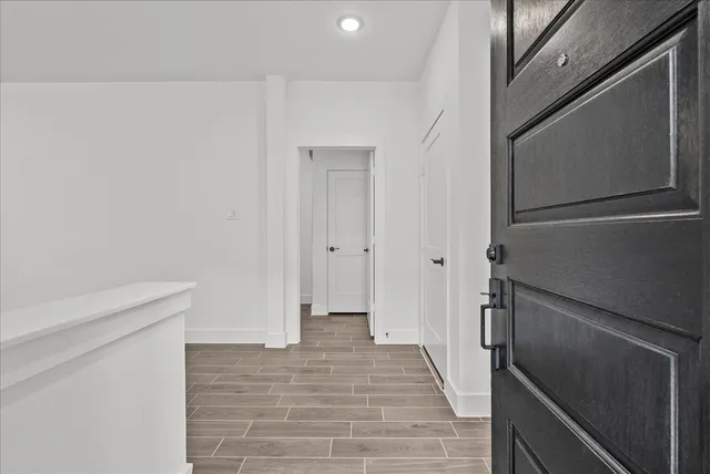 a view of a hallway with wooden floor and staircase
