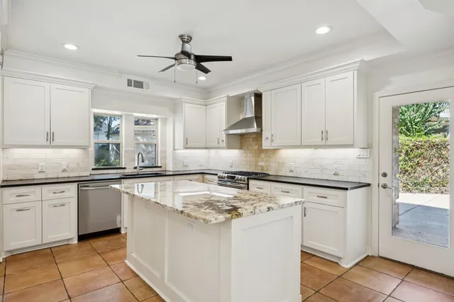 a kitchen with granite countertop cabinets stainless steel appliances a sink and a window