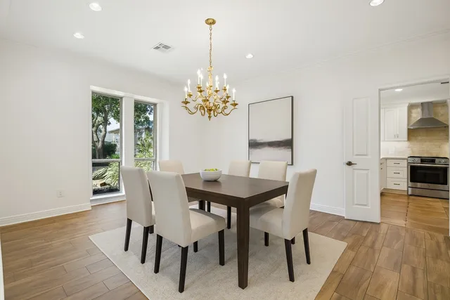 a view of a dining room with furniture a chandelier and wooden floor