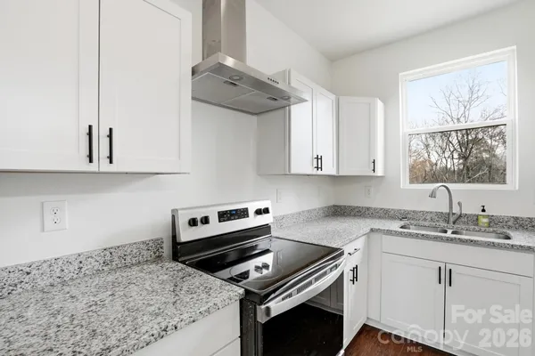 a kitchen with white cabinets and appliances