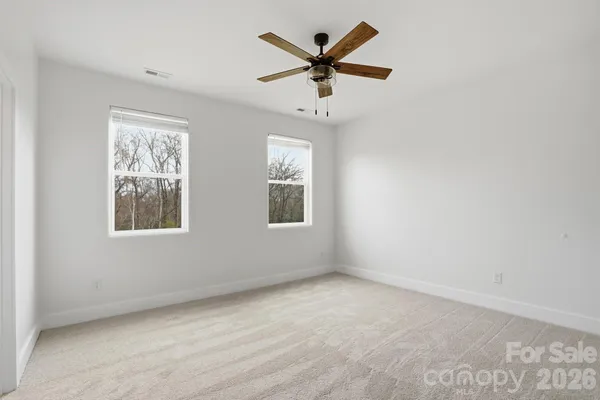 an empty room with a window and a fan