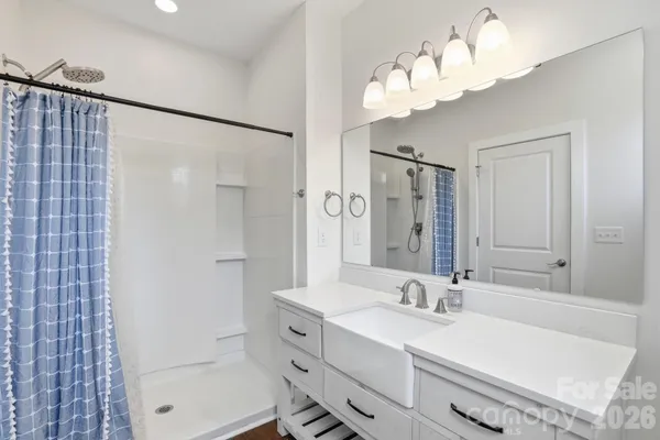 a bathroom with a double vanity sink mirror and shower