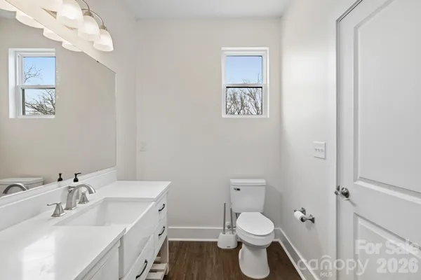 a bathroom with a toilet a sink and mirror
