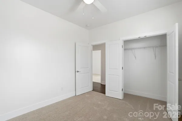 an empty room with chandelier fan