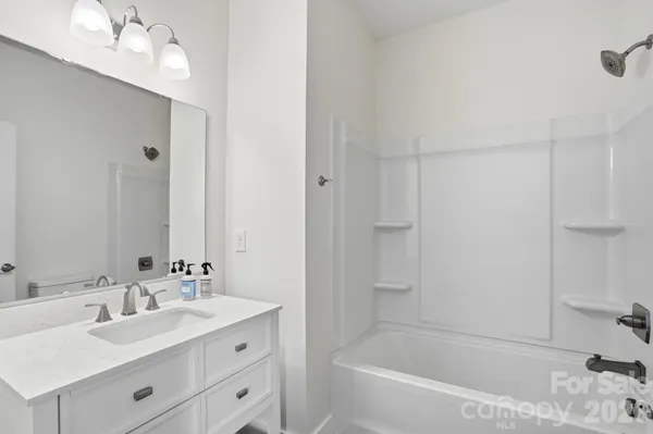 a bathroom with a tub toilet sink vanity and mirror