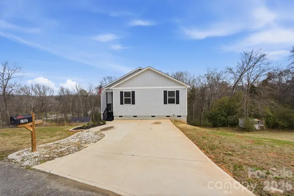 a view of a house with backyard and trees