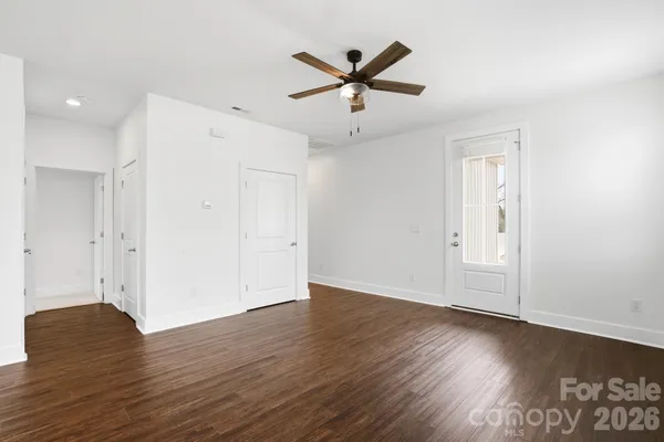 a view of a livingroom with wooden floor and a ceiling fan
