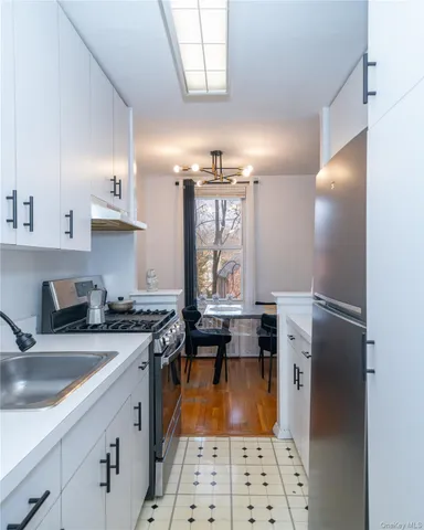 a kitchen with a sink a stove a refrigerator and cabinets