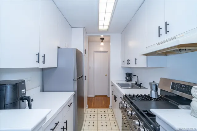 a kitchen with stainless steel appliances a stove a sink and a refrigerator