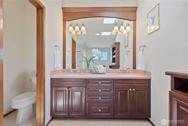 a bathroom with a granite countertop toilet a sink and a mirror