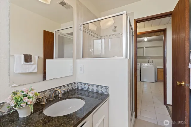 a bathroom with a granite countertop sink and a mirror