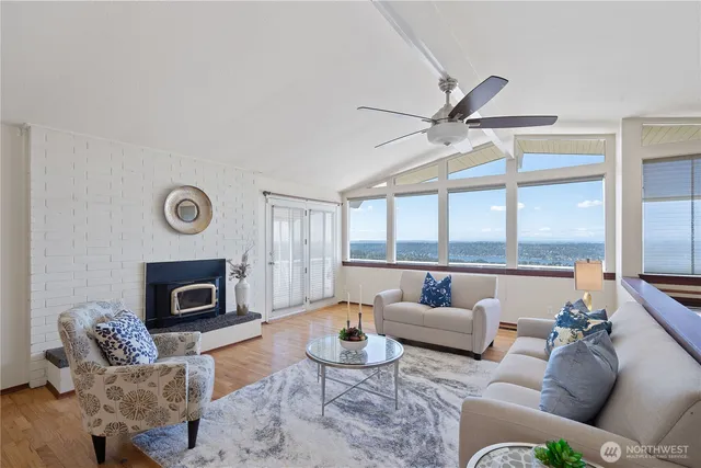 a living room with furniture a fireplace and a large window