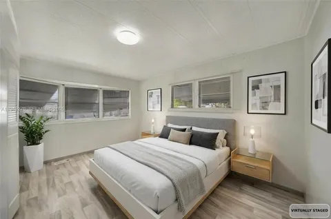 a bedroom with a large bed and a potted plant