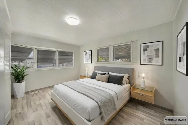 a bedroom with a large bed and a potted plant