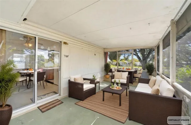 a living room with furniture a floor to ceiling window and potted plant
