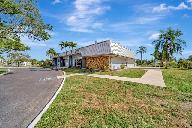 a view of a house with a yard and potted plants