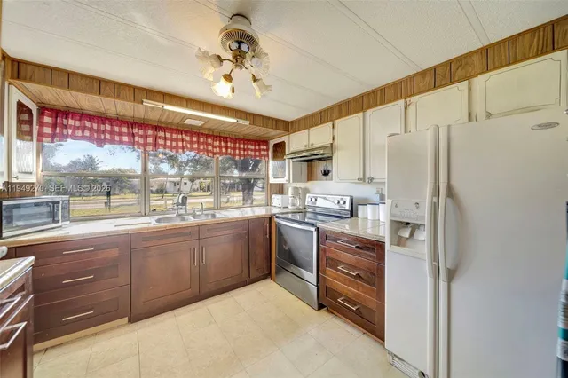 a kitchen with stainless steel appliances granite countertop a refrigerator and a stove top oven