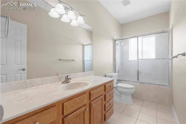 a bathroom with a sink a toilet and large mirror