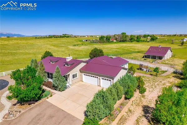an aerial view of a house with a garden and lake view