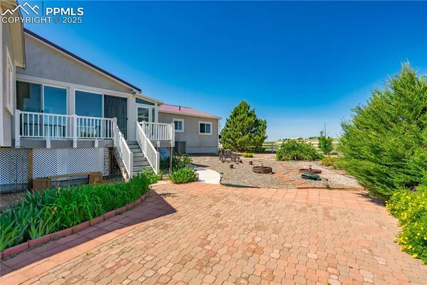 a view of a house with a yard and potted plants