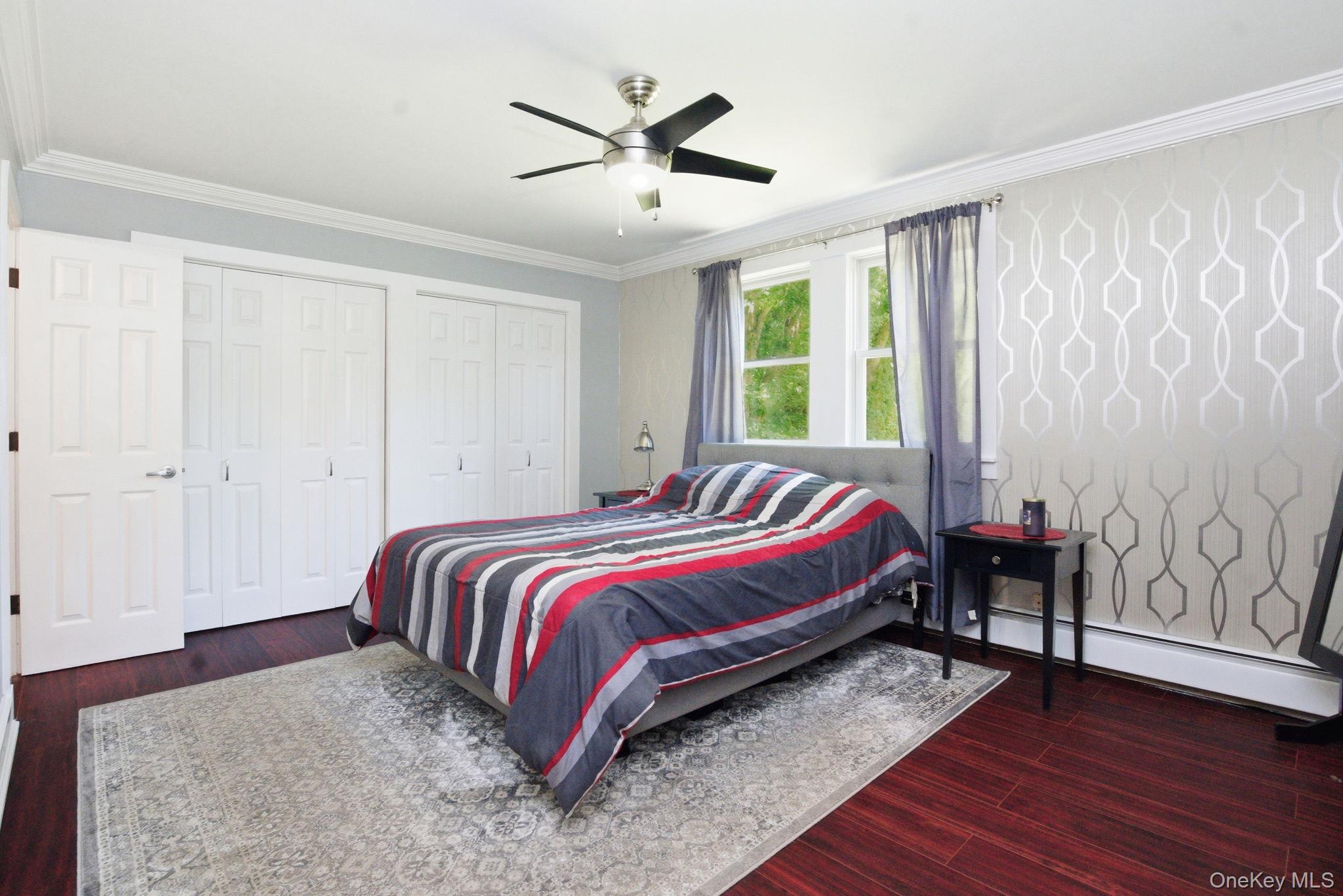 35 Deans Bridge Road Somers, NY 10589 - Photo 18 of 49 A spacious primary bedroom with rich flooring, custom crown molding, and generous double closets, overlooking spacious backyard and pond.