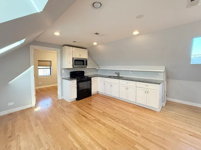 a large kitchen with stainless steel appliances granite countertop a stove and a sink