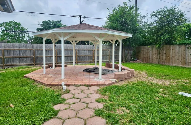 a view of a patio with a table and chairs under an umbrella