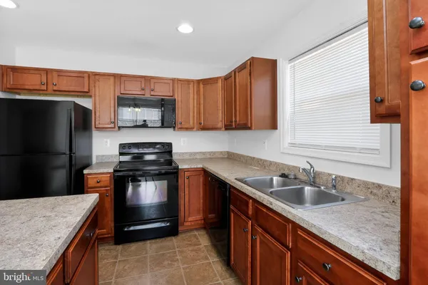 a kitchen with stainless steel appliances granite countertop a refrigerator a sink and a stove