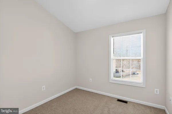 an empty room with a ceiling fan and window