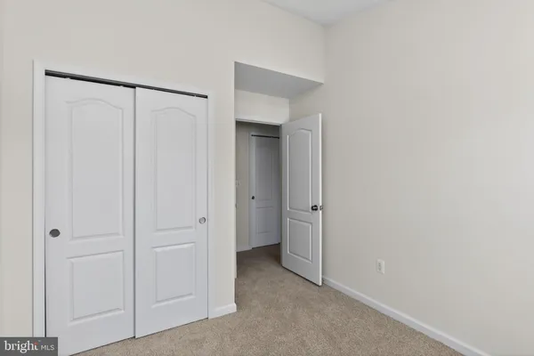 an empty room with closet and a chandelier fan