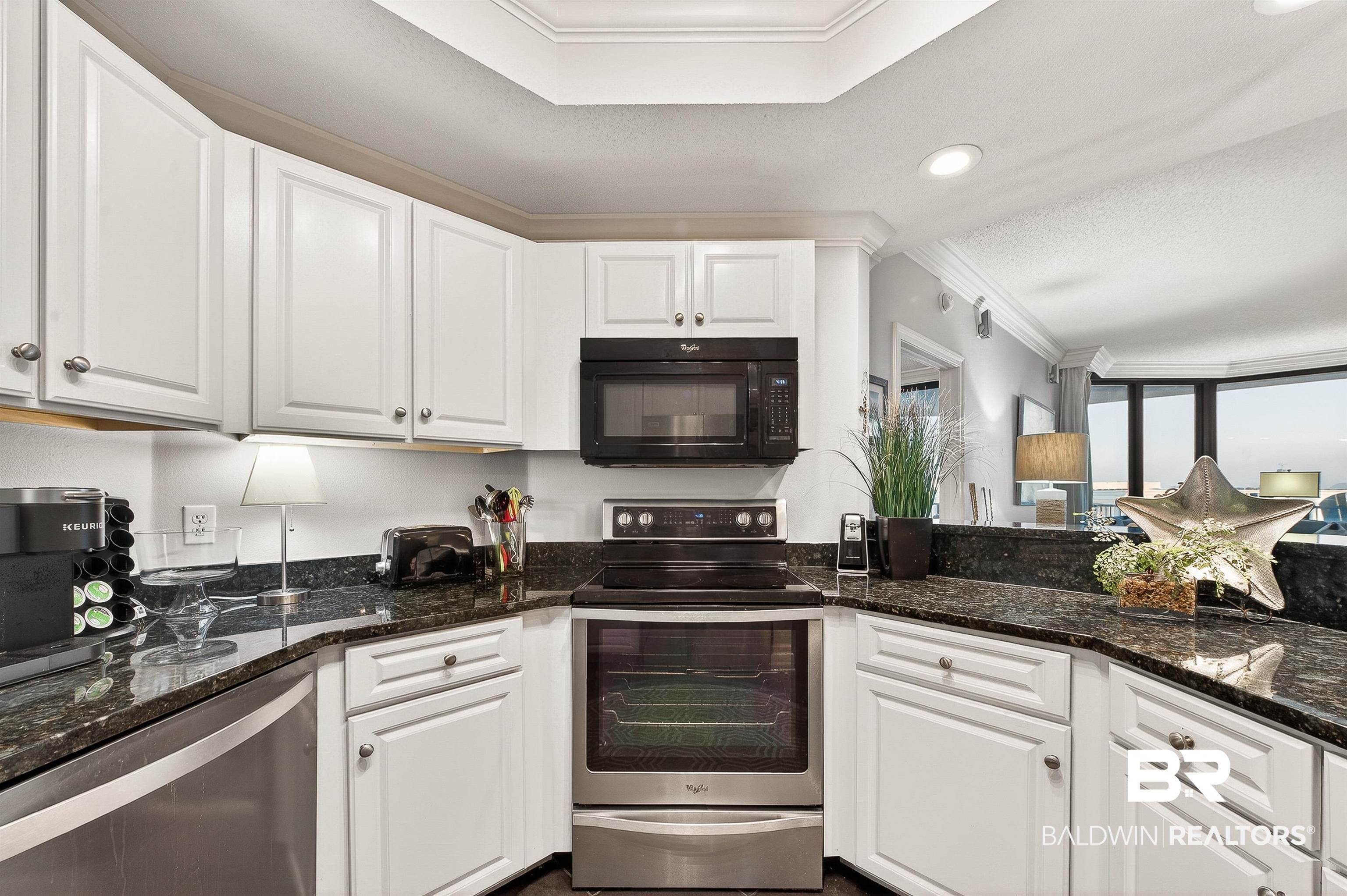 27582 Canal Road, Unit 2507 Orange Beach, AL 36561 - Photo 24 of 75 Kitchen with crown molding, stainless steel appliances, white cabinets, dark stone counters, and a textured ceiling