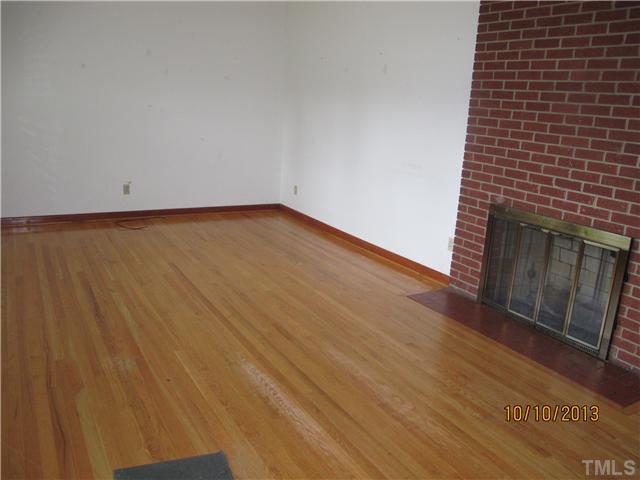 3912 Donna Road Raleigh, NC 27604 - Photo 2 of 13 a view of an empty room with wooden floor and a fireplace