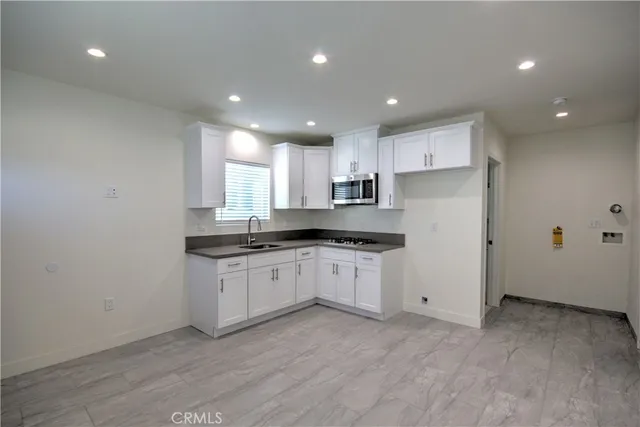 a kitchen with granite countertop white cabinets and white appliances