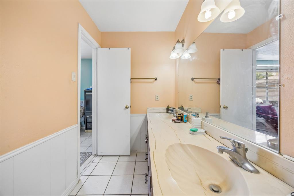 1701 East Spring Valley Road Richardson, TX 75081 - Photo 18 of 28 Dual vanity with integrated sinks, full-width mirror, and tile flooring
