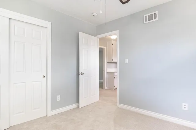 a view of a big room with windows and chandelier fan