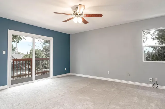 a view of an empty room and a ceiling fan