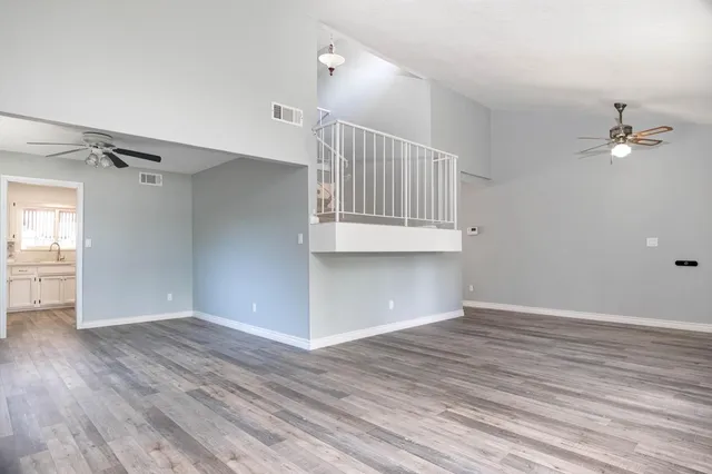 a view of an empty room with a window and wooden floor