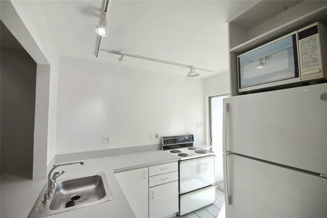 a kitchen with a refrigerator sink and cabinets
