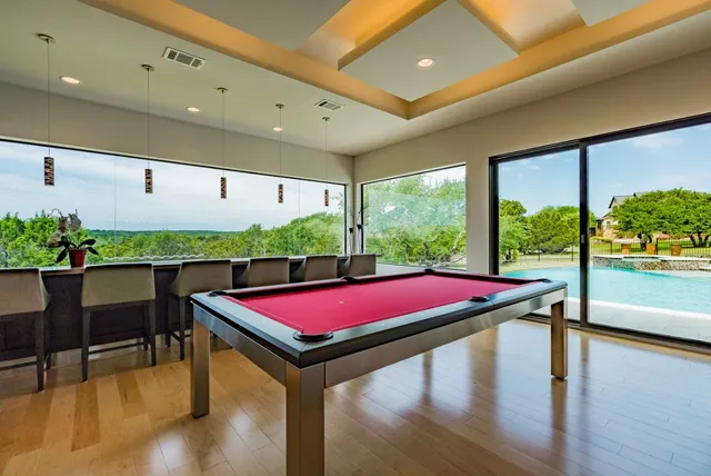 a room with pool table and windows