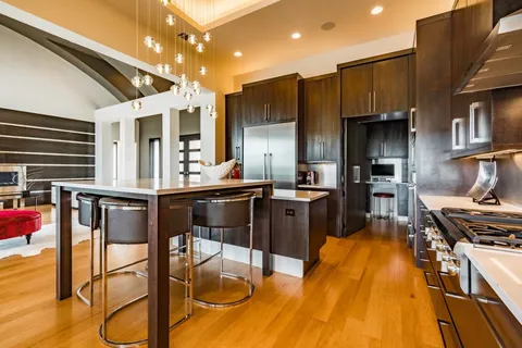 a kitchen with stainless steel appliances granite countertop a stove top oven a sink and a refrigerator