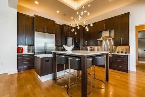 a kitchen with stainless steel appliances kitchen island granite countertop a refrigerator and a stove top oven