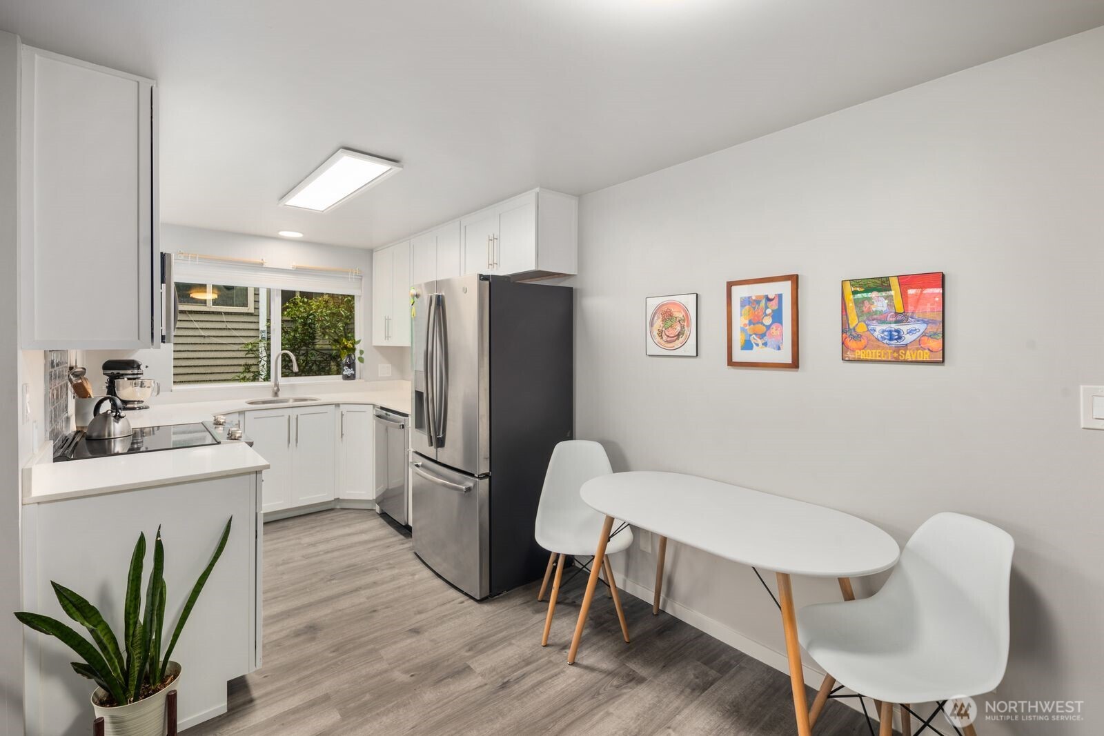 1729 18th Avenue, Unit 201 Seattle, WA 98122 - Photo 11 of 31 a kitchen with a refrigerator a sink dishwasher a dining table and chairs with wooden floor